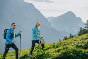 a man and a woman hiking on a hill at Landhotel Das Stocker in Vorderstoder