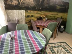 a dining room with a table and chairs and a painting at B&B Villa Maurizio in Tsqaltubo