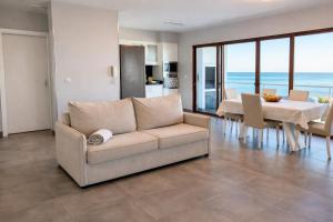 a living room with a couch and a table with chairs at Villa O Pomar with optional heated pool in Paul do Mar