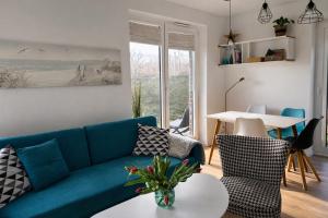 a living room with a blue couch and a table at Apartament Vespa in Mechelinki +27 photos