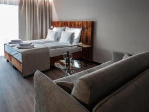 a bedroom with a bed and two chairs and a couch at Piano Property Rental Wrocław in Wrocław