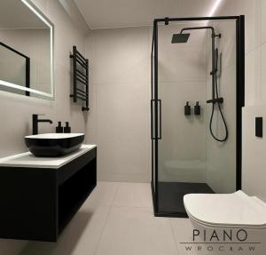 a bathroom with a shower and a sink and a toilet at Piano Property Rental Wrocław in Wrocław +36 photos
