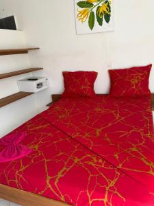 a bedroom with a red comforter on a bed at Villa Bella Vista in Hell-Ville +5 photos