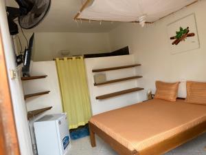 a small bedroom with a bed and a yellow curtain at Villa Bella Vista in Hell-Ville