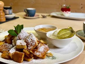 a plate of food on a table with powdered sugar at Hotel Schlehdorn in Feldberg