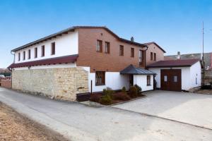 a white and brown house with a driveway at Penzion Na Chalupě in Polička