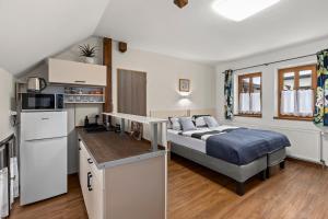 a small bedroom with a bed and a kitchen at Penzion Na Chalupě in Polička