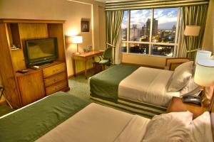 a hotel room with two beds and a television at InterTower Hotel in Santa Fe