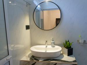 a bathroom with a white sink and a mirror at Blue Cinnamon Cove in Kosgoda