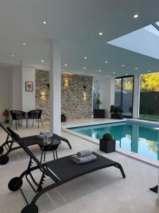 a living room with a swimming pool and a table and a pool at Studio de Charme Paris in Rocquencourt