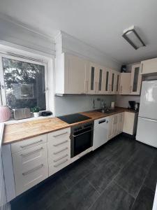 a kitchen with white cabinets and a black stove at Stylish 2-bedrooms apartment, smart TV, Netflix, parking - Oslo in Oslo