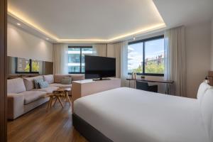a hotel room with a bed and a couch at Hotel SB Icaria in Barcelona