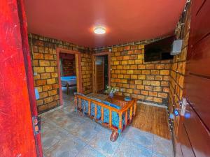 a room with a brick wall with a bench in it at Zambeze Lodge in Marracuene