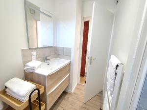 a white bathroom with a sink and a mirror at Yvéro in Quend-Plage +13 photos