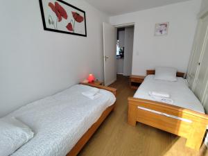 two twin beds in a room with white walls at Yvéro in Quend-Plage