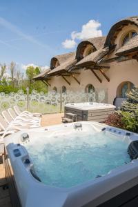 a hot tub in front of a house at Dworek Góralski Restauracja Hotel & SPA in Łodygowice