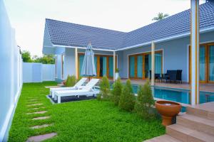 a backyard with a pool and a house with a umbrella at Samui Tropical Pool Villas in Ban Li Pa Noi