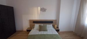 a bedroom with a bed with a wooden headboard at Camposa2025 in Muxia