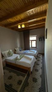 a room with three beds and a television in it at Alisher hotel in Samarkand