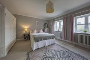 a bedroom with a bed with pink pillows at Appletree House in Sway