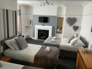 a hotel room with two beds and a fireplace at Sheridans hotel in Wallasey
