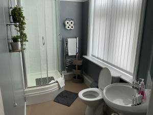 a bathroom with a shower and a toilet and a sink at Sheridans hotel in Wallasey +45 photos