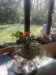 a vase filled with flowers on a table next to a window at Campe-Good in Kampenhout