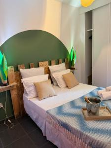 a bedroom with a large bed with a green headboard at Kaz'Baduel piscine, terrasse, wifi et climatisation in Cayenne +58 photos