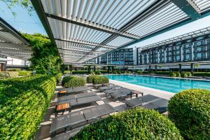an outdoor swimming pool with lounge chairs and a building at Voya Beach Resort - Ultra All Inclusive in Sveti Vlas