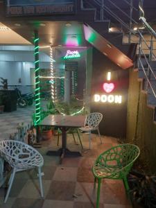 a room with two chairs and a table and a door at Cozy bunks z hostel in Dehradun