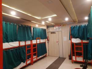 a room with three bunk beds with green curtains at Cozy bunks z hostel in Dehradun