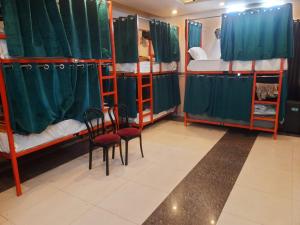 a room with two chairs and bunk beds at Cozy bunks z hostel in Dehradun