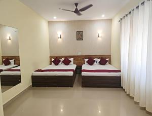 a bedroom with two beds and a ceiling fan at SAI GUEST house in Calangute
