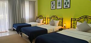 a hotel room with two beds and green walls at SAI GUEST house in Calangute