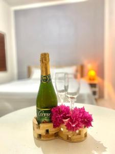 a bottle of champagne sitting on a table with flowers at Apart hotel Refúgio tropical Icarai de amontada in Amontada
