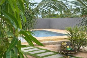 a swimming pool in a yard with a fence at Apart hotel Refúgio tropical Icarai de amontada in Amontada