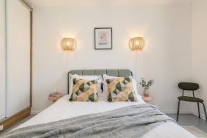 a bedroom with a bed and two lights on the wall at FurtiveStay - Les Sablons - Orléans in Neuilly-sur-Seine