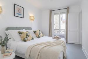 a white bedroom with a large white bed and a window at FurtiveStay - Les Sablons - Orléans in Neuilly-sur-Seine