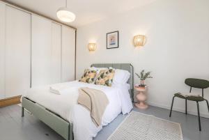 a bedroom with a bed with white sheets and pillows at FurtiveStay - Les Sablons - Orléans in Neuilly-sur-Seine