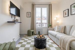 a living room with a couch and a tv at FurtiveStay - Les Sablons - Orléans in Neuilly-sur-Seine +6 photos