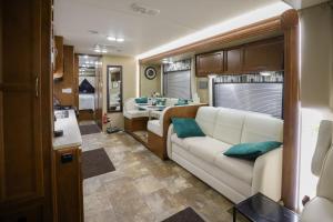 a living room with a couch and a kitchen at Kamper 30m2 max 4 osoby in Ciężkowice