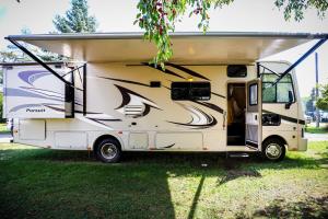 an rv parked in the grass with its door open at Kamper 30m2 max 4 osoby in Ciężkowice