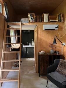 ein kleines Zimmer mit einem Etagenbett und einem Schreibtisch in der Unterkunft Tiny de Paula in Saint-Hubert