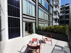 ein Balkon mit Stühlen und Tischen an einem Gebäude in der Unterkunft Olivia Lisboa Hotel in Lissabon
