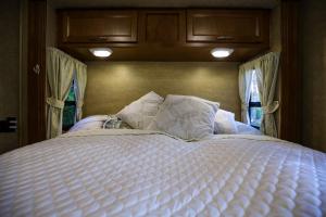 a large white bed in a room with windows at Kamper 30m2 max 4 osoby in Ciężkowice