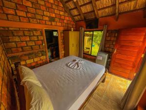 a bedroom with a bed in a brick wall at Zambeze Lodge in Marracuene