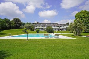 a large house with a swimming pool in the grass at Petronella - Gardagate in Soiano del Lago