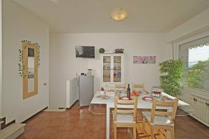 a kitchen with a table with chairs and a refrigerator at Petronella - Gardagate in Soiano del Lago