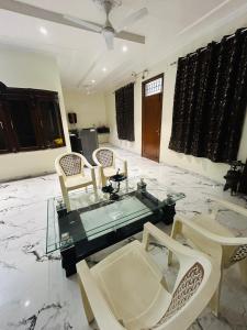 a living room with a glass table and chairs at Wonderstays in Amritsar