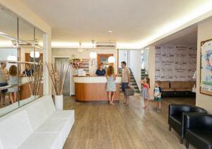 a group of people standing at a counter in a lobby at Hotel Consul Dipendenza "la Plata" con piscina in Riccione +46 photos